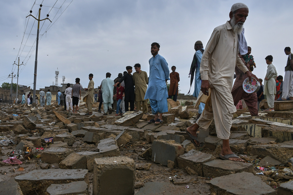 Local residents examine the rubble of a boundary wall collapsed due to heavy rains and strong winds in Karachi, Pakistan, Thursday, March 19, 2026. (AP Photo/Ali Raza)