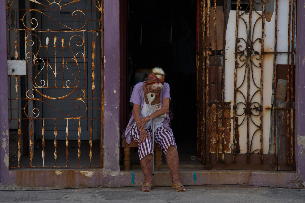An elderly woman sits in the doorway of her home to catch the cool air during a blackout in Havana, Cuba, Friday, Sept. 18, 2026. (AP Photo/Ramon Espinosa)