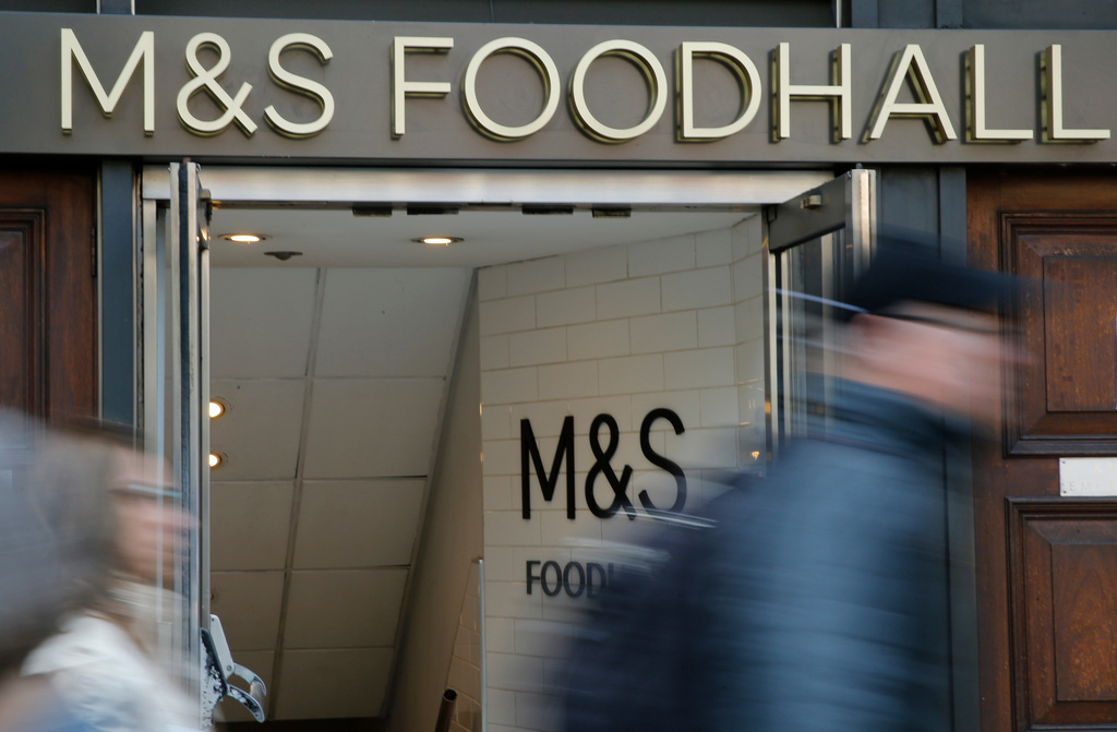 People walk past a branch of British clothing and food store Marks and Spencer in London, Wednesday, May 23, 2018. (AP Photo/Alastair Grant)