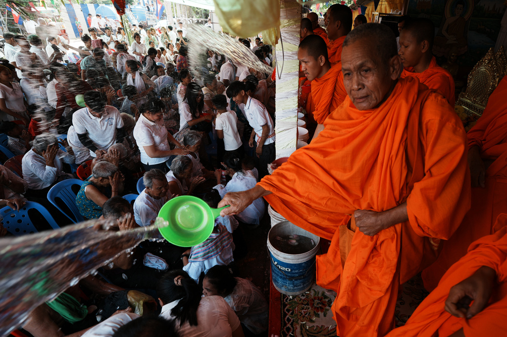 Local residents of Prey Popel village receive holy water from Buddhist monks, right, a ritual believed to bring good luck, during Khmer New Year celebrations on the outskirts of Phnom Penh, Cambodia, Sunday, April 12, 2026. (AP Photo/Heng Sinith)