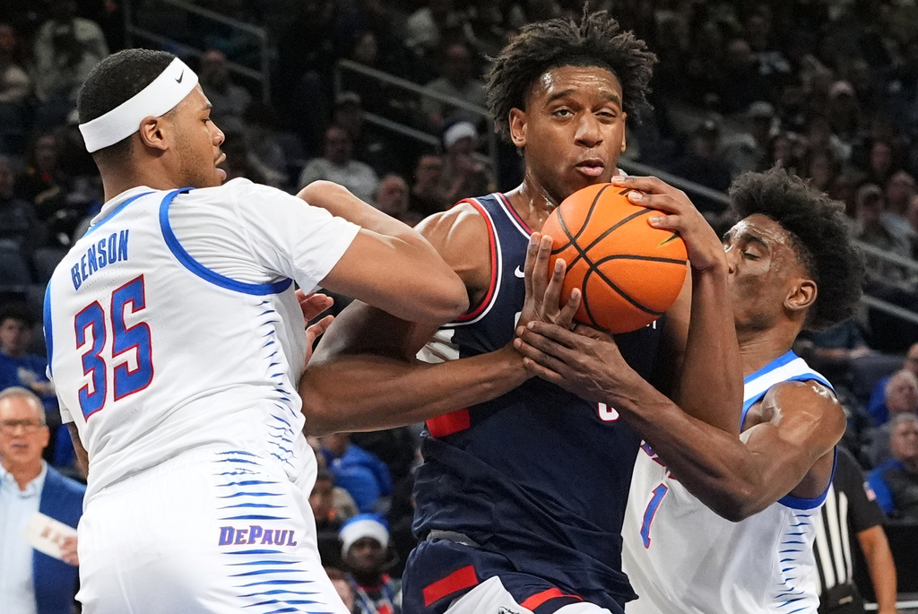 UConn center Tarris Reed Jr., center, drives against DePaul forward Nj Benson, left, and forward Kaleb Banks during the first half of an NCAA college basketball game in Chicago, Sunday, Dec. 21, 2025. (AP Photo/Nam Y. Huh)