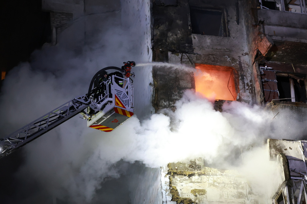 Rescue workers try to put out a fire of a residential building burning after a Russian drone attack on Zaporizhzhia, Ukraine, Tuesday, March 24, 2026. (AP Photo/Kateryna Klochko)