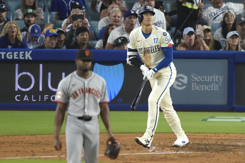 Los Angeles Dodgers' Shohei Ohtani, left, heads to first for a solo home run as San Francisco Giants relief pitcher Joel Peguero watches during the sixth inning of a baseball game, Saturday, Sept. 20, 2025, in Los Angeles. (AP Photo/Mark J. Terrill)