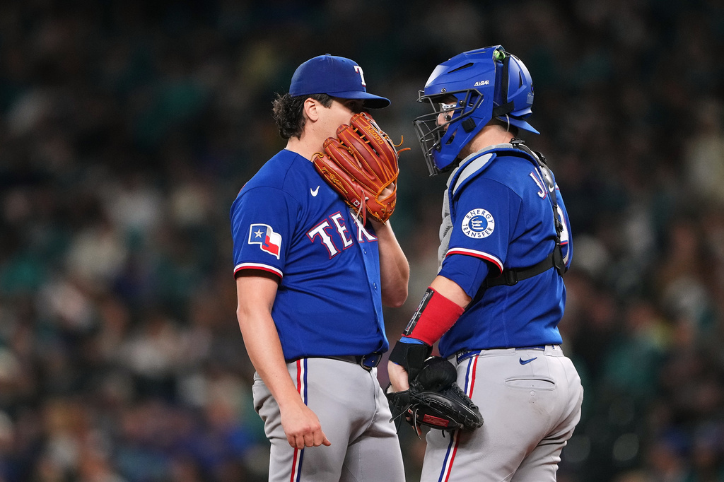 Texas Rangers starting pitcher Cal Quantrill talks with catcher Danny Jansen, right, during the fourth inning of a baseball game against the Seattle Mariners, Tuesday, Sept. 8, 2026, in Seattle. (AP Photo/Lindsey Wasson)