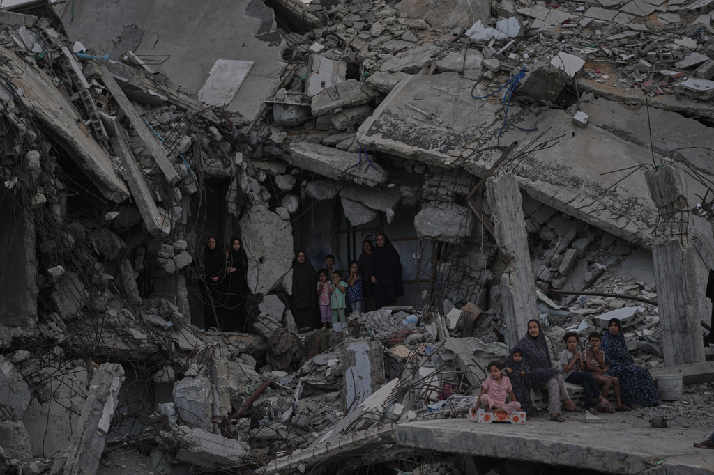 Palestinian women and children watch the Palestine Strongman Championship from among the rubble of destroyed buildings in Gaza City, Friday, Oct. 16, 2026. (AP Photo/Jehad Alshrafi)