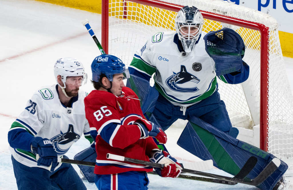 Vancouver Canucks goaltender Nikita Tolopilo (60) watches the puck in front of Montreal Canadiens' Alexandre Texier (85) as Canucks' Marcus Pettersson (29) defends during second-period NHL hockey game action in Montreal, Monday, Jan. 12, 2026. (Christinne Muschi/The Canadian Press via AP)