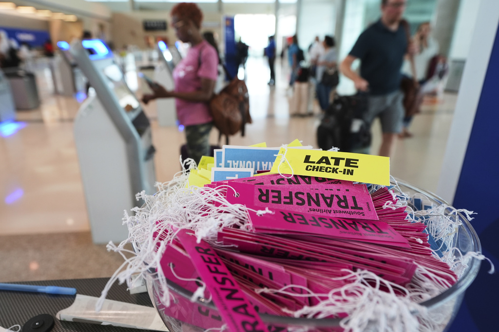 Labels available to travelers sit in a bowl by a kiosk at a ticketing gate at Dallas Love Field Airport, Friday, Aug. 29, 2025, in Dallas. (AP Photo/Tony Gutierrez)
