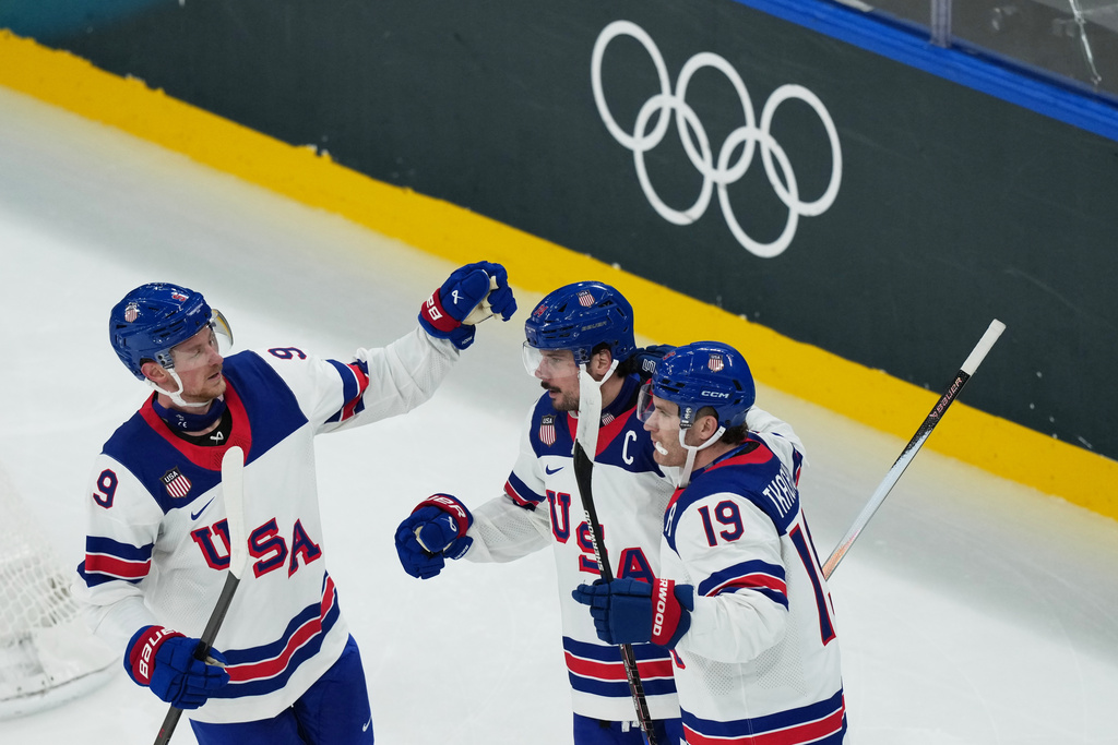 United States' Auston Matthews, center, celebrates with teammates after scoring his sides fifth goal during a preliminary round match of men's ice hockey between Latvia and the United States at the 2026 Winter Olympics, in Milan, Italy, Thursday, Feb. 12, 2026. (AP Photo/Carolyn Kaster)