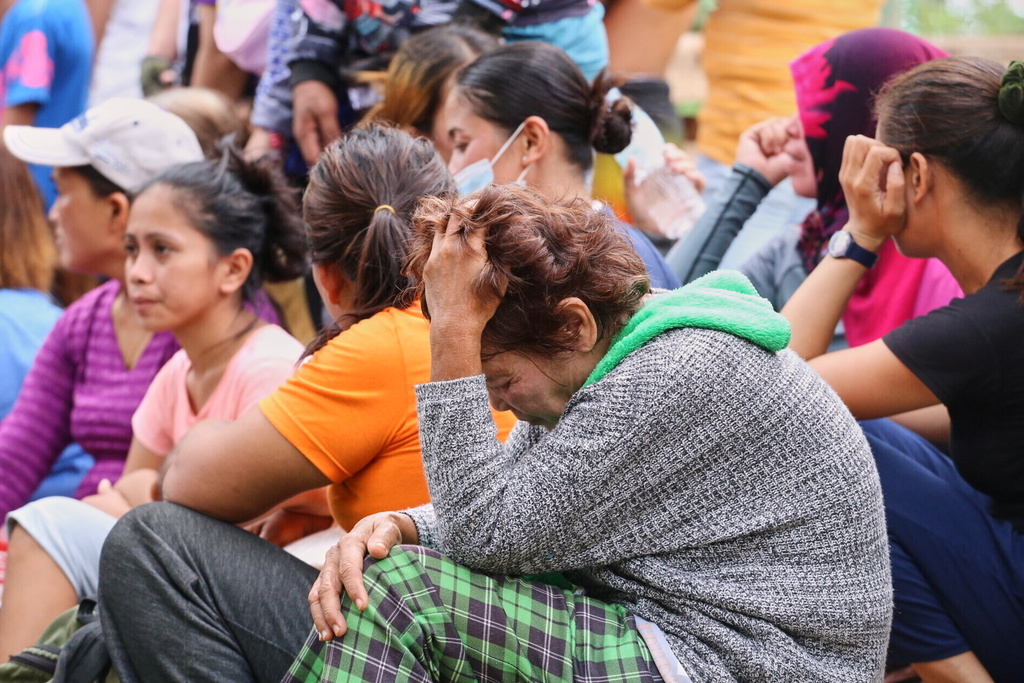 Relatives and others wait for updates after a huge mound of garbage collapsed at a waste segregation facility in Binaliw, Cebu city on Friday, Jan. 9, 2026. (AP Photo/Jacqueline Hernandez)