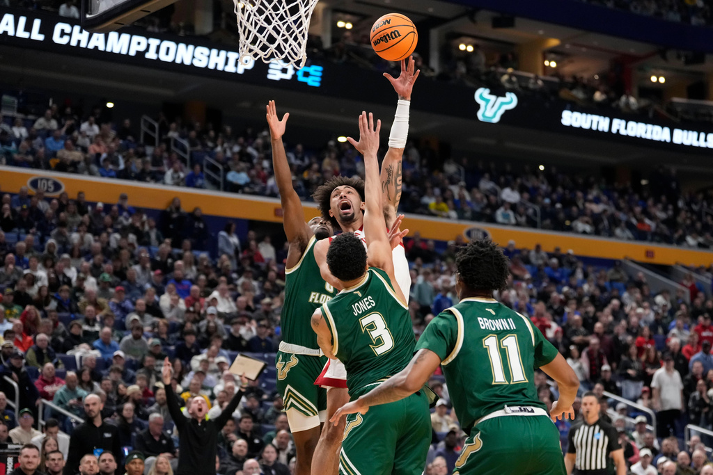 Louisville guard J'vonne Hadley (1) shoots over South Florida guard Isaiah Jones (3) during the first half in the first round of the NCAA college basketball tournament, Thursday, March 19, 2026, in Buffalo, N.Y. (AP Photo/Yuki Iwamura)