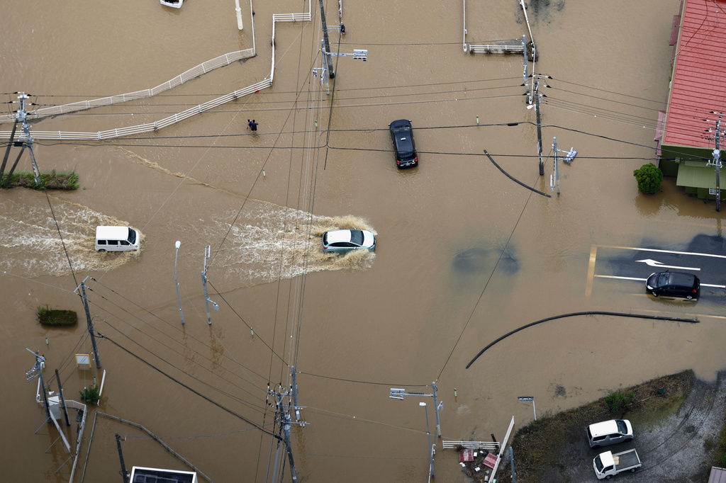 Cars make their way through flooded road after heavy rain in Oamishirasato, Chiba prefecture, Japan, Friday, Aug. 14, 2026. (Kota Endo/Kyodo News via AP)