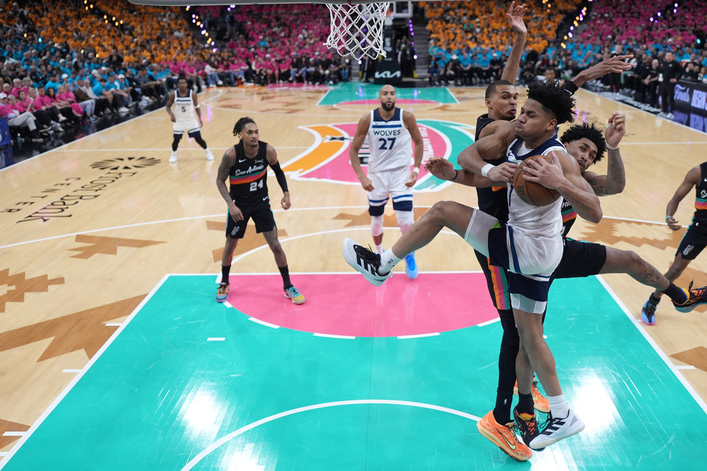 Minnesota Timberwolves guard Terrence Shannon Jr. (1), front, handles the ball as San Antonio Spurs guard Dylan Harper (2), middle, and forward-center Victor Wembanyama (1), back, defend during the second half in Game 1 of a second-round NBA playoffs basketball series in San Antonio, Monday, May 4, 2026. (AP Photo/Eric Gay)