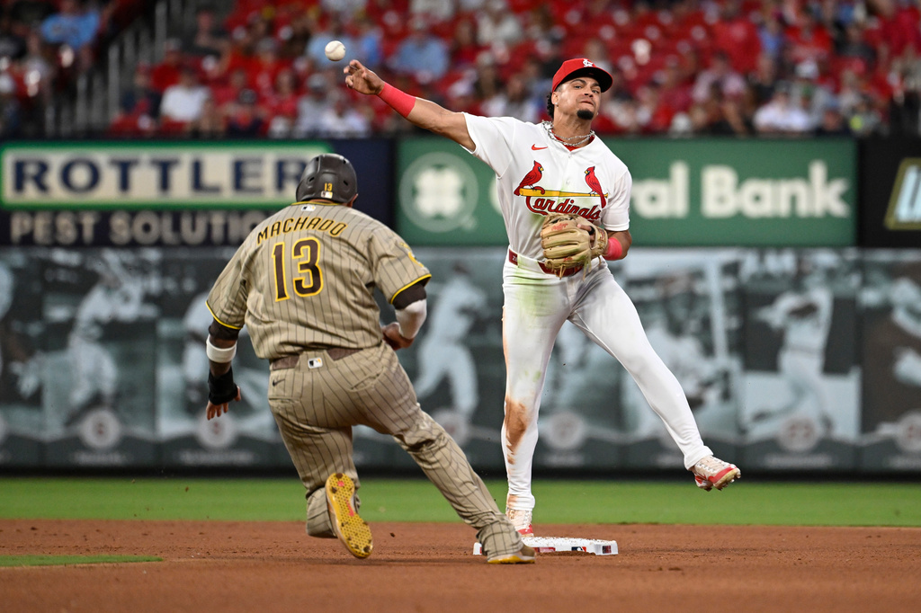 San Diego Padres' Manny Machado (13) is out at second base as St. Louis Cardinals shortstop Masyn Winn, right, turns a double play in the seventh inning of a baseball game, Monday, June 15, 2026, in St. Louis. (AP Photo/Joe Puetz)