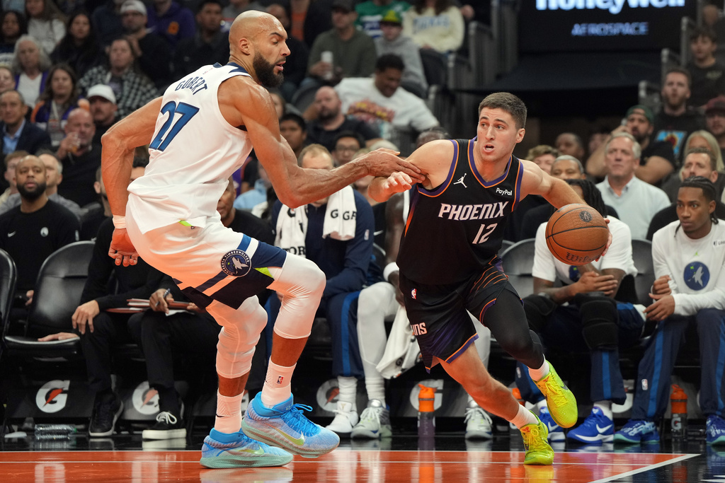 Phoenix Suns guard Collin Gillespie, right, drives past Minnesota Timberwolves center Rudy Gobert (27) during the first half of an NBA Cup basketball game, Friday, Nov. 21, 2025, in Phoenix. (AP Photo/Rick Scuteri)