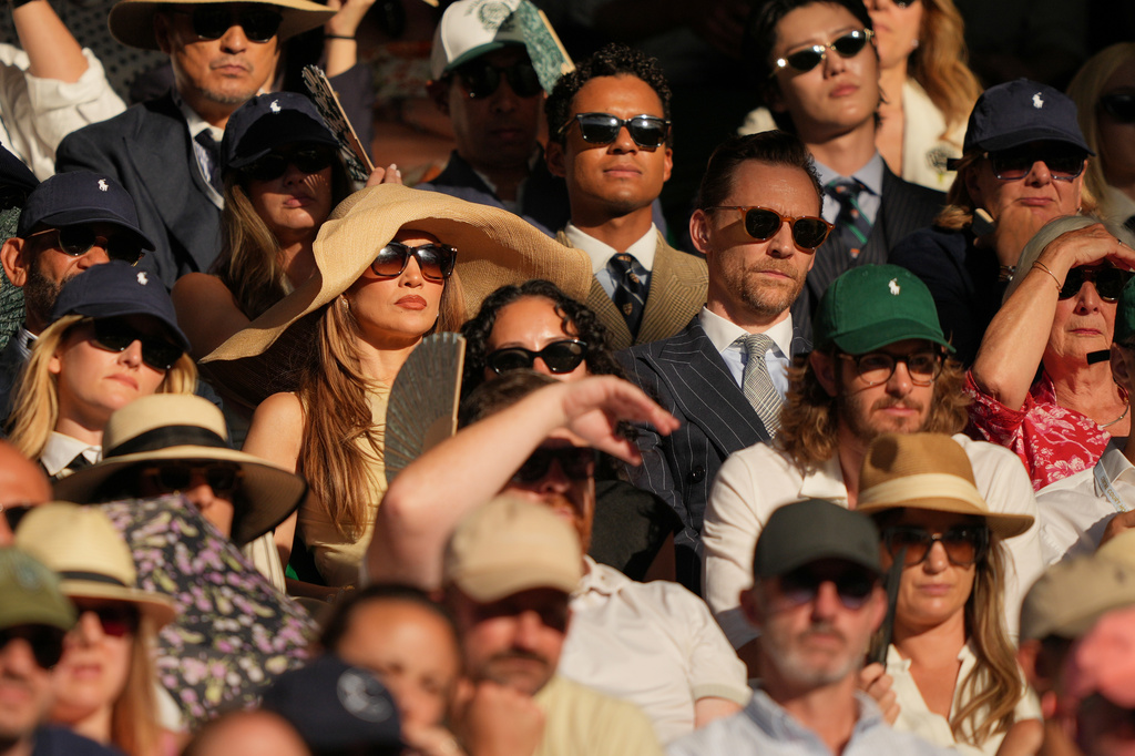 Singer Jennifer Lopez, centre, and Actor Tom Hiddleston watch the men's singles final at Wimbledon Tennis Championships in London, Sunday, July 12, 2026. (AP Photo/Kin Cheung)