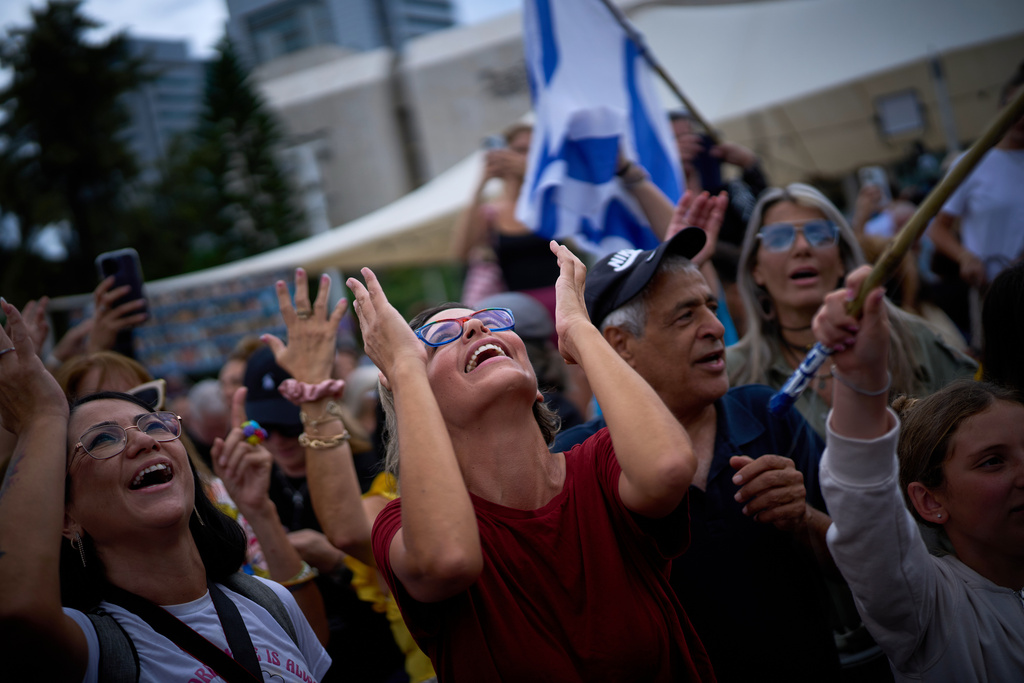 People react as they celebrate following the announcement that Israel and Hamas have agreed to the first phase of a peace plan to pause the fighting, at a plaza known as hostages square in Tel Aviv, Israel, Thursday, Oct. 9, 2025. (AP Photo/Emilio Morenatti)