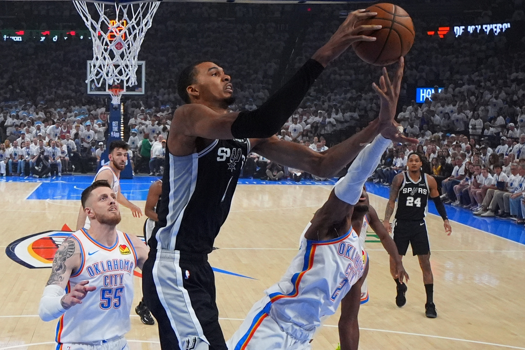 San Antonio Spurs forward Victor Wembanyama (1) and Oklahoma City Thunder guard Shai Gilgeous-Alexander (2) vie for a loose ball in the first half of Game 5 in the Western Conference finals NBA basketball playoffs series, Tuesday, May 26, 2026, in Oklahoma City. (AP Photo/Julio Cortez)