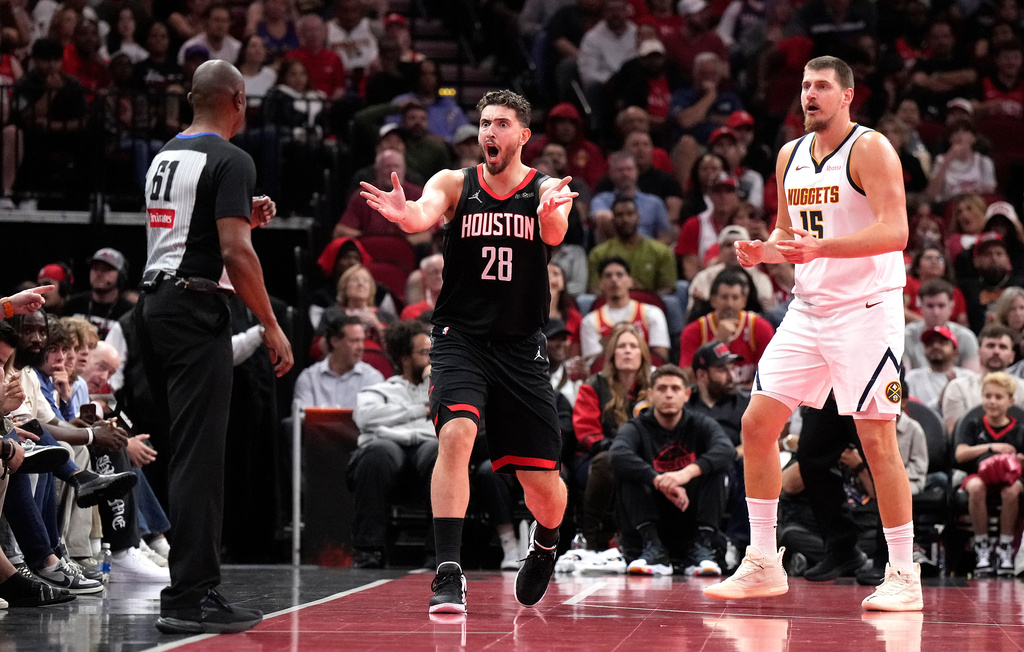Houston Rockets center Alperen Sengun (28) questions a call from referee Courtney Kirkland (61) with Denver Nuggets center Nikola Jokic (15) during the first half of an NBA Cup basketball game, Friday, Nov. 21, 2025, in Houston. (AP Photo/Karen Warren)