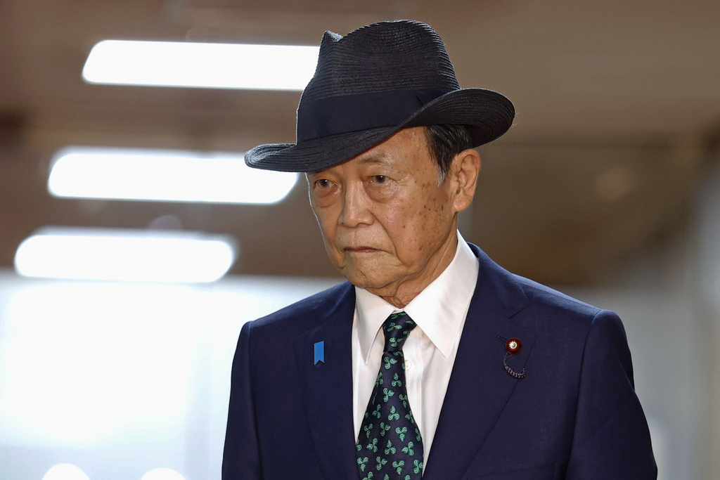 Former Prime Minister Taro Aso walks at the headquarters of the ruling Liberal Democratic Party, after meeting with newly-elected party leader Sanae Takaichi, on Oct. 5, 2025, in Tokyo. (Kyodo News via AP)