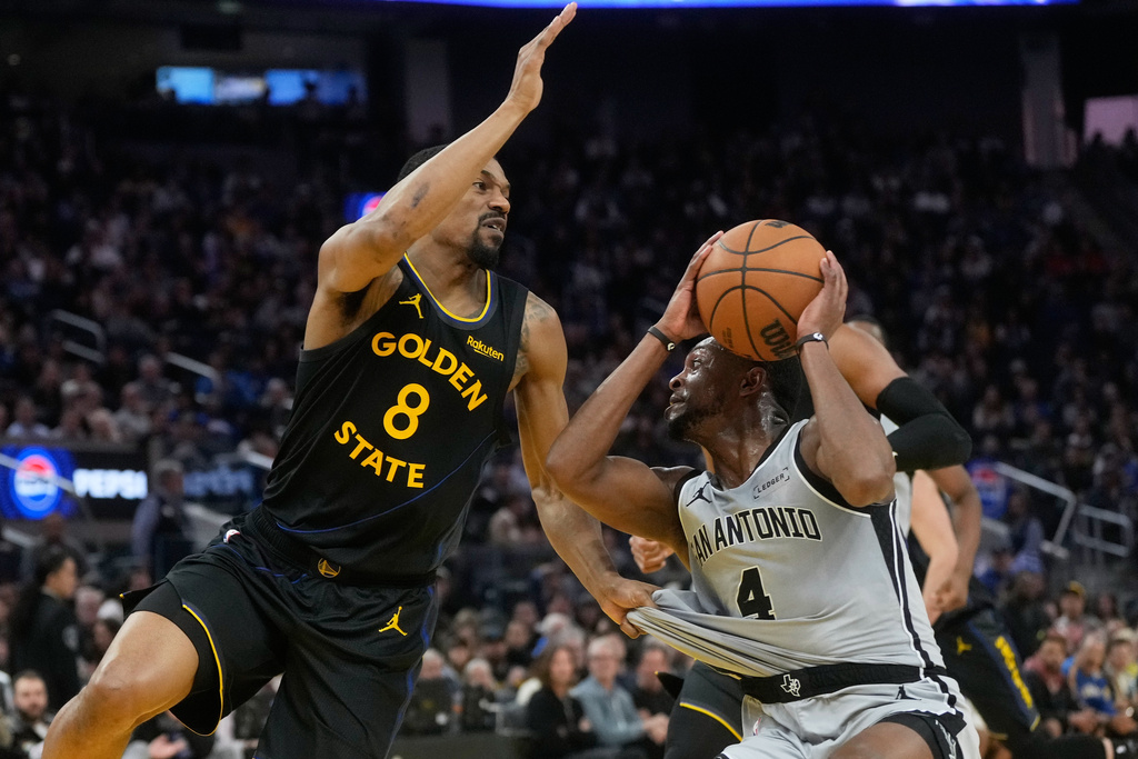 Golden State Warriors guard De'anthony Melton (8) grabs the jersey of San Antonio Spurs guard De'Aaron Fox (4) during the first half of an NBA basketball game in San Francisco, Wednesday, Feb. 11, 2026. (AP Photo/Jeff Chiu)
