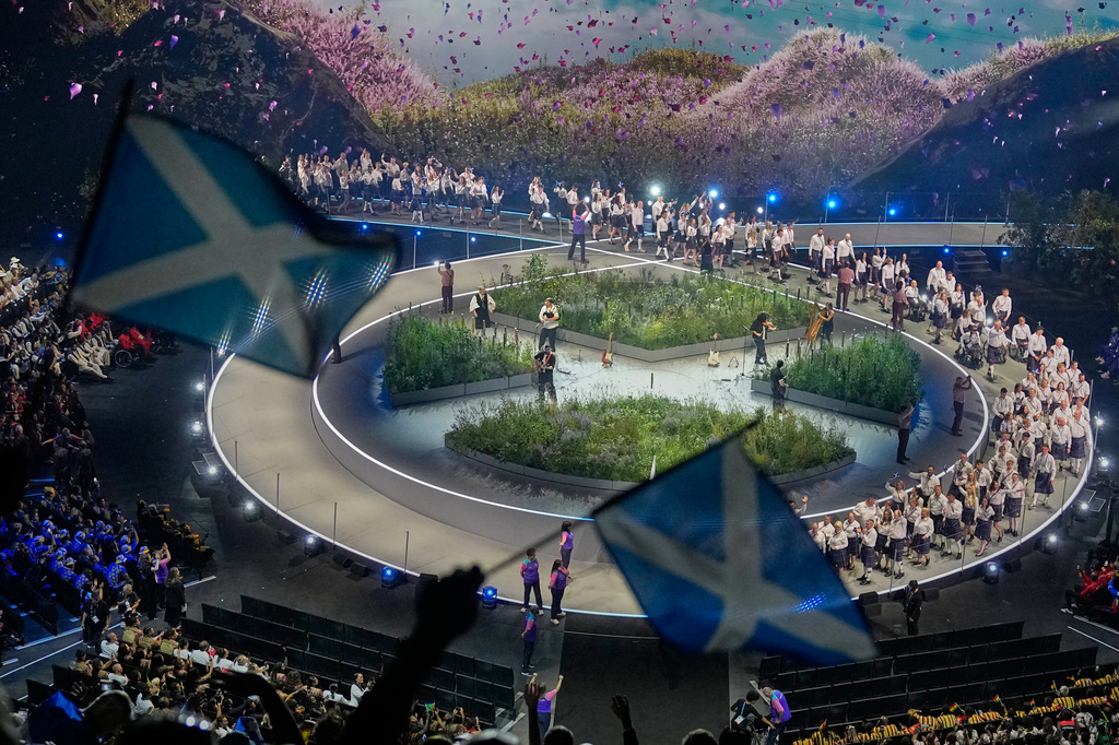 Scottish flags are waved by fans as the Scotland team arrives on stage during the Commonwealth Games opening ceremony in Glasgow, Scotland, Thursday, July 23, 2026. (AP Photo/Manish Swarup)