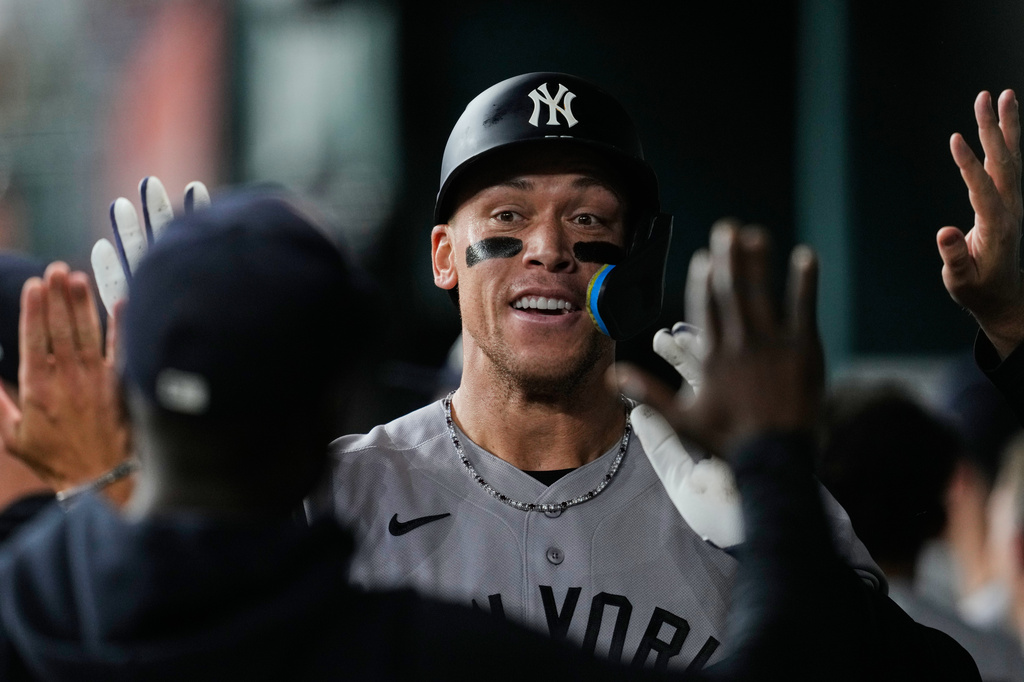 New York Yankees' Aaron Judge celebrates in the dugout with the team after hitting a solo home run in the third inning of a baseball game against the Texas Rangers Monday, April 27, 2026, in Arlington, Texas. (AP Photo/Tony Gutierrez)