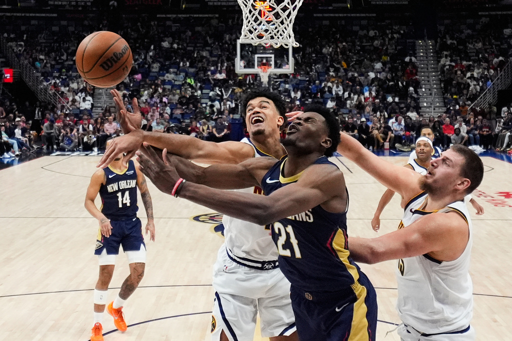 New Orleans Pelicans center Yves Missi (21) battles under the basket between Denver Nuggets forward Spencer Jones, left, and center Nikola Jokic in the second half of an NBA basketball game, Wednesday, Nov. 19, 2025, in New Orleans. (AP Photo/Gerald Herbert)