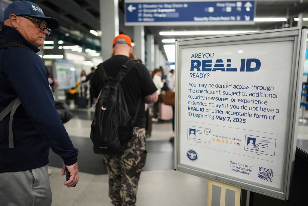 FILE - Travelers walk past a Real ID sign posted inside terminal 3 at O'Hare International Airport in Chicago, Friday, May 23, 2025. (AP Photo/Nam Y. Huh, File)