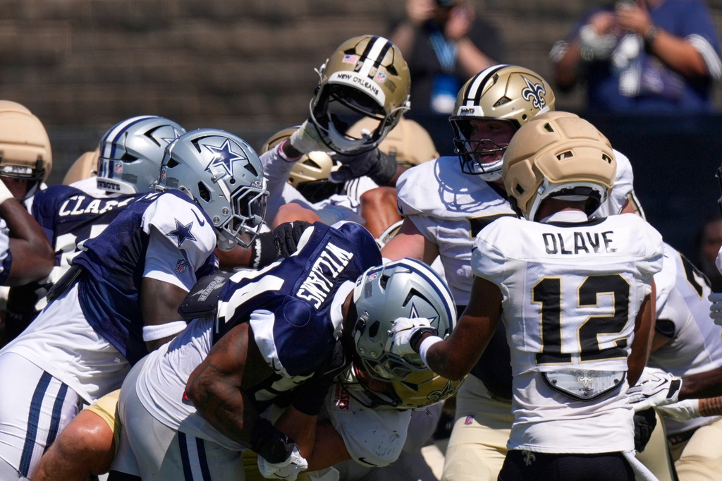 A helmet belonging to a member of the New Orleans Saints is ripped off during a scrum during an NFL football joint practice, Tuesday, Aug. 18, 2026, in Oxnard, Calif. (AP Photo/Mark J. Terrill)