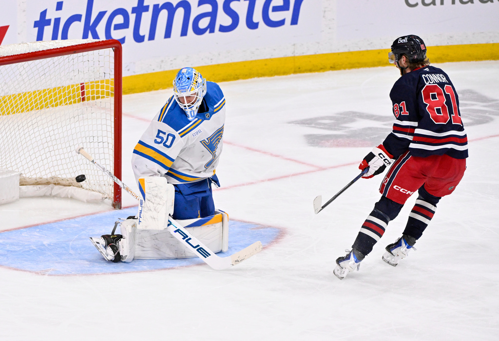 Winnipeg Jets' Kyle Connor (81) scores against St. Louis Blues goaltender Jordan Binnington (50) during third-period NHL hockey game action in Winnipeg, Manitoba, Sunday March 15, 2026. (Fred Greenslade/The Canadian Press via AP)
