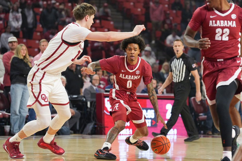 Alabama guard Labaron Philon Jr., right, looks for an opening past Oklahoma center Kirill Elatontsev during the first half of an NCAA college basketball game, Saturday, Jan. 17, 2026, in Norman, Okla. (AP Photo/Kyle Phillips)