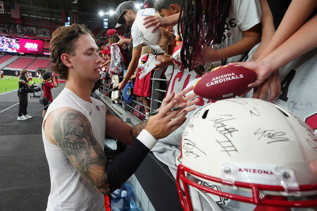 Arizona Cardinals' Carson Beck signs autographs after practice at the NFL football team's training camp, Sunday, Aug. 2, 2026, in Glendale, Ariz. (AP Photo/Ross D. Franklin)