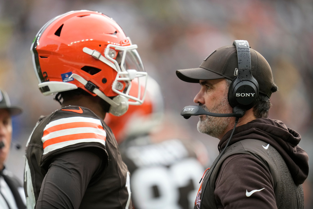 Cleveland Browns head coach Kevin Stefanski talks with quarterback Shedeur Sanders, left, during the first half of an NFL football game against the Pittsburgh Steelers, Sunday, Dec. 28, 2025, in Cleveland. (AP Photo/Sue Ogrocki)