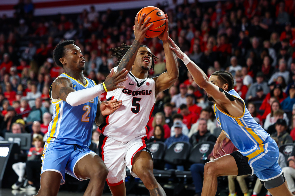 LIU Brooklyn guards Greg Gordon, left, and Jomo Goings, right, defend against Georgia guard Jeremiah Wilkinson, center, during the first half of an NCAA college basketball game Monday, Dec. 29, 2025, in Athens, Ga. (AP Photo/Colin Hubbard)