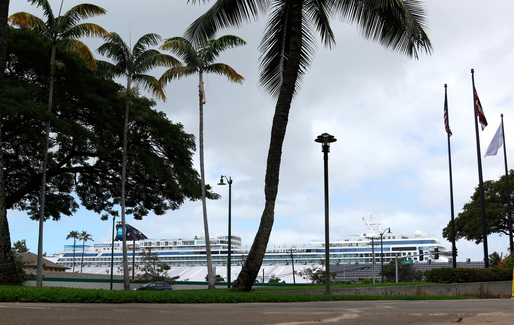 FILE - The Norwegian Jewel, background, is docked in Honolulu, March 23, 2020. (AP Photo/Caleb Jones, File)