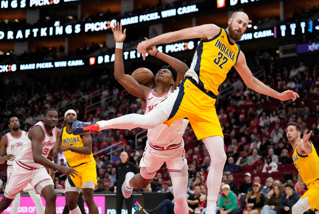 Indiana Pacers center Jay Huff (32) fouls Houston Rockets guard Amen Thompson, left, under the basket during the first half of an NBA basketball game Monday, Dec. 29, 2025, in Houston. (AP Photo/Karen Warren)