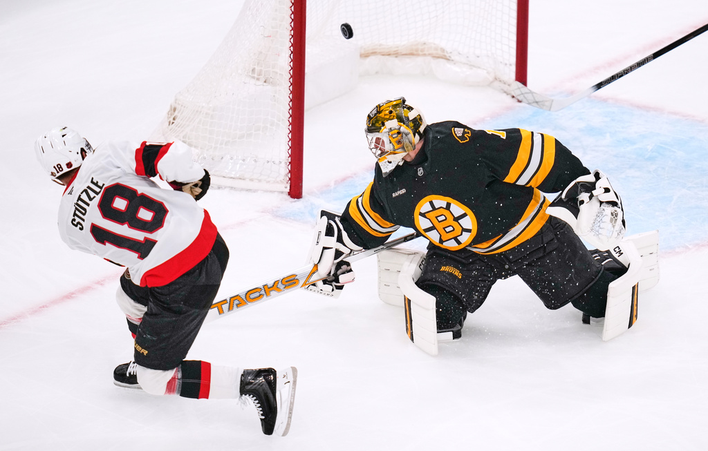 Ottawa Senators' Tim St&uuml;tzle (18) scores against Boston Bruins' Jeremy Swayman, right, during the first period of an NHL hockey game, Monday, Oct. 5, 2026, in Boston. (AP Photo/Charles Krupa)