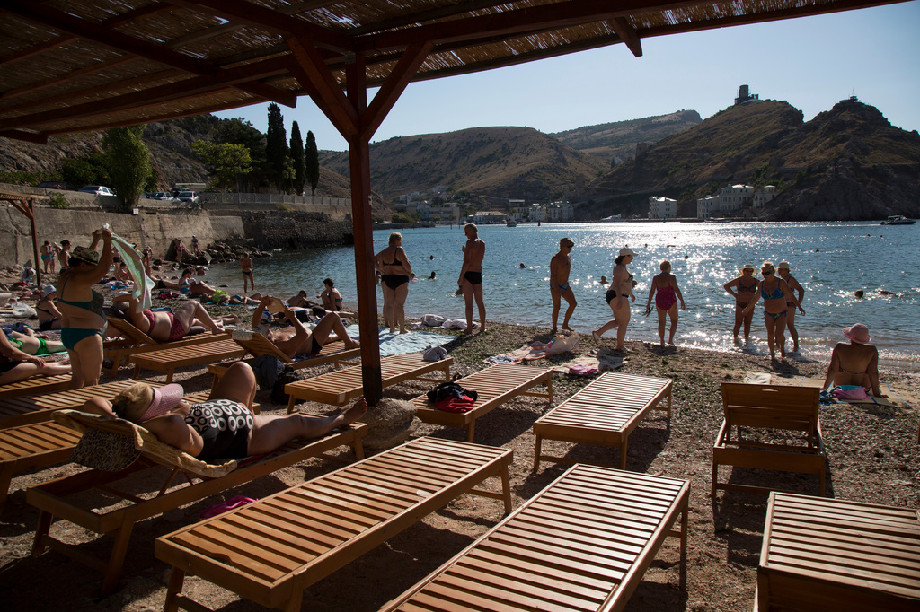 FILE - People gather at the beach in Balaklava Bay, a part of Sevastopol on the Crimean Peninsula, on Sunday, Aug. 9, 2015. (AP Photo/Alexander Zemlianichenko, File)