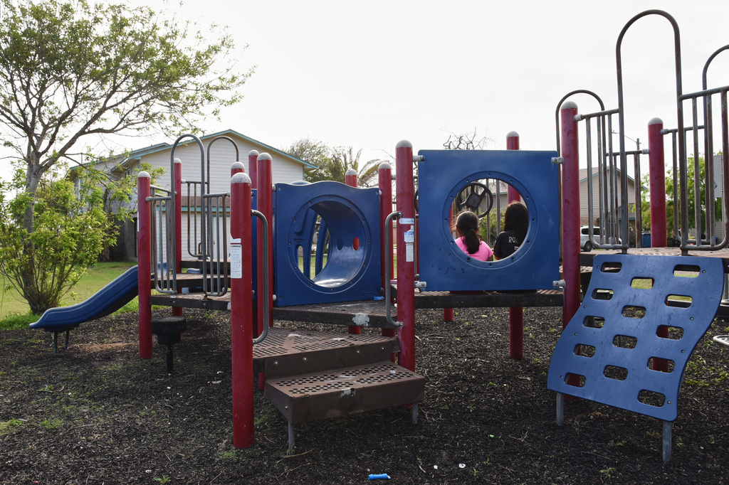 Two sisters play in a neighborhood playground that sits mostly vacant, April 13, 2026, after neighbors left their public housing homes in Port Isabel, Texas. (AP Photo/Valerie Gonzalez)