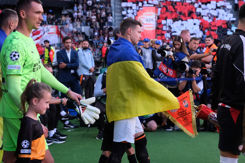 Shakhtar Donetsk players draped in Ukrainian flags enter the stadium before the Champions League opening phase soccer match between PSV Eindhoven and Shakhtar Donetsk in Eindhoven, Netherlands, Thursday, Sept. 10, 2026. (AP Photo/Patrick Post)