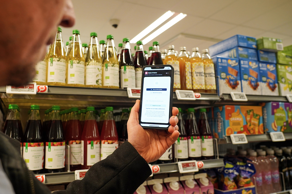 Ian Rosenfeldt, the creator of "Made O'Meter" mobile app, demonstrates how shoppers can use the application to identify and boycott American goods in a grocery store in Copenhagen, Wednesday, Jan. 28, 2026. (AP Photo/James Brooks)