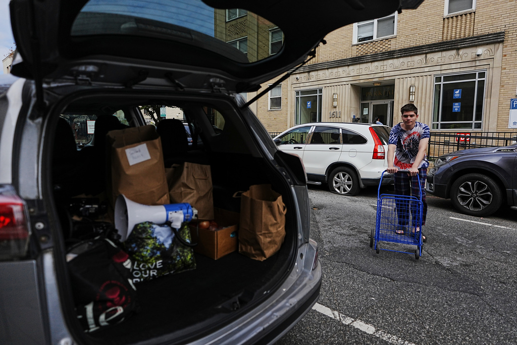 A parishioner of the Shrine of the Sacred Heart waits with his cart to load donated food delivered by church volunteers to those who are afraid to leave home for groceries due to immigration raids in Washington, Oct. 11, 2025. (AP Photo/Luis Andres Henao)