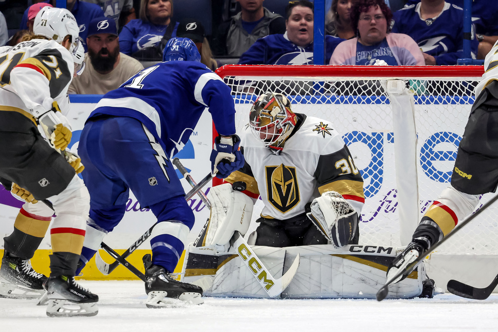 In his NHL debut, Vegas Golden Knights goaltender Carl Lindbom (30) makes a save against Tampa Bay Lightning's Anthony Cirelli (71) during the first period of a hockey game Sunday, Oct. 26, 2025, in Tampa, Fla. (AP Photo/Mike Carlson)