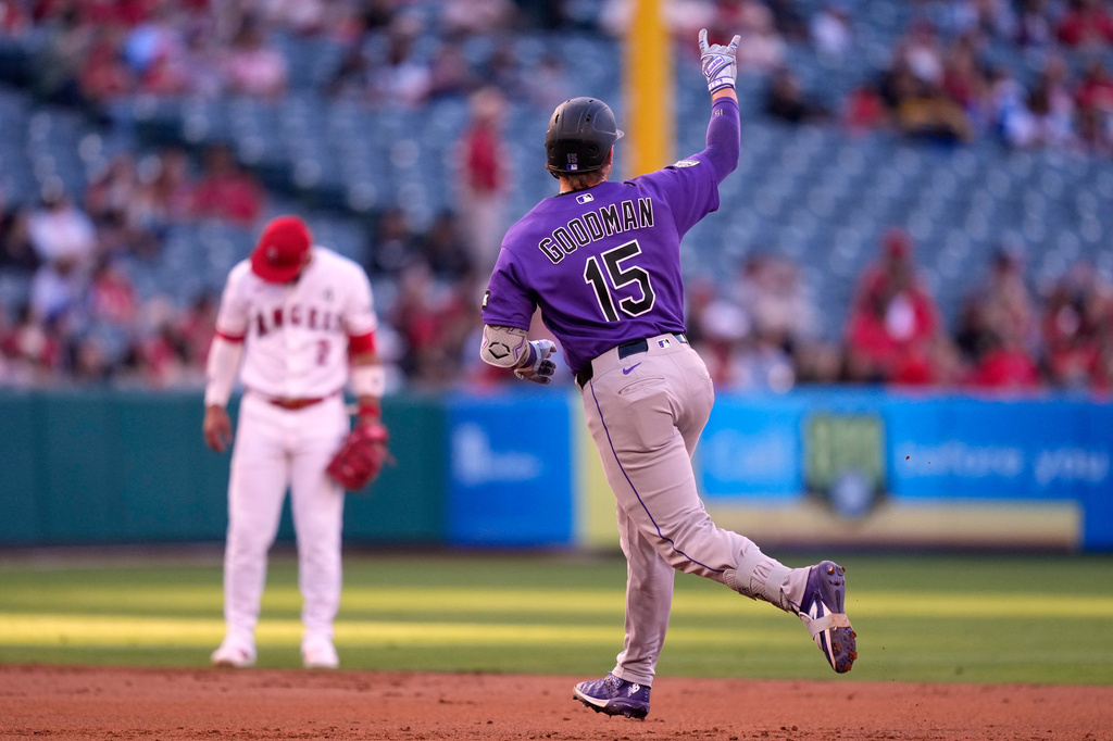 Colorado Rockies' Hunter Goodman, right, gestures as he rounds second while Los Angeles Angels shortstop Oswald Peraza stands by during the second inning of a baseball game Tuesday, June 2, 2026, in Anaheim, Calif. (AP Photo/Mark J. Terrill)