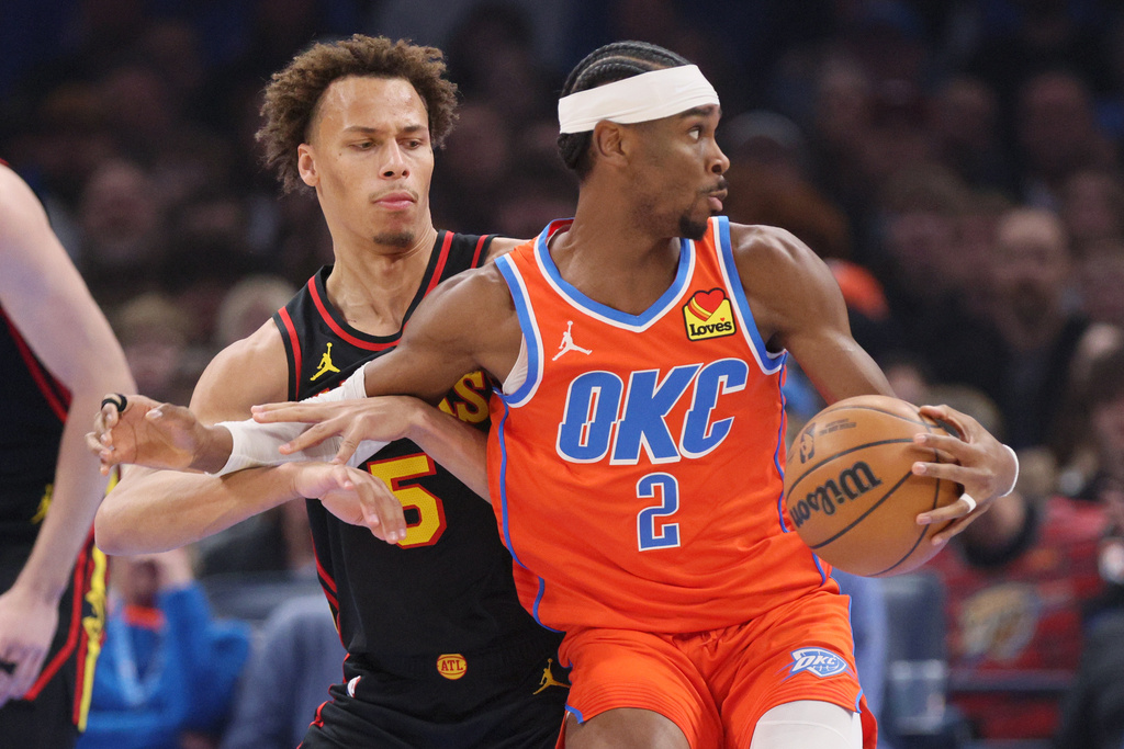 Oklahoma City Thunder guard Shai Gilgeous-Alexander (2) spins away from Atlanta Hawks guard Dyson Daniels, left, during the first half of an NBA basketball game Monday, Dec. 29, 2025, in Oklahoma City. (AP Photo/Nate Billings)