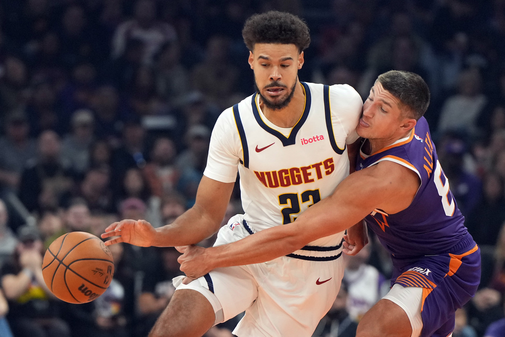 Phoenix Suns guard Grayson Allen, right, pressures Denver Nuggets forward Cameron Johnson, left, during the first half of an NBA basketball game, Saturday, Nov. 29, 2025, in Phoenix. (AP Photo/Rick Scuteri)