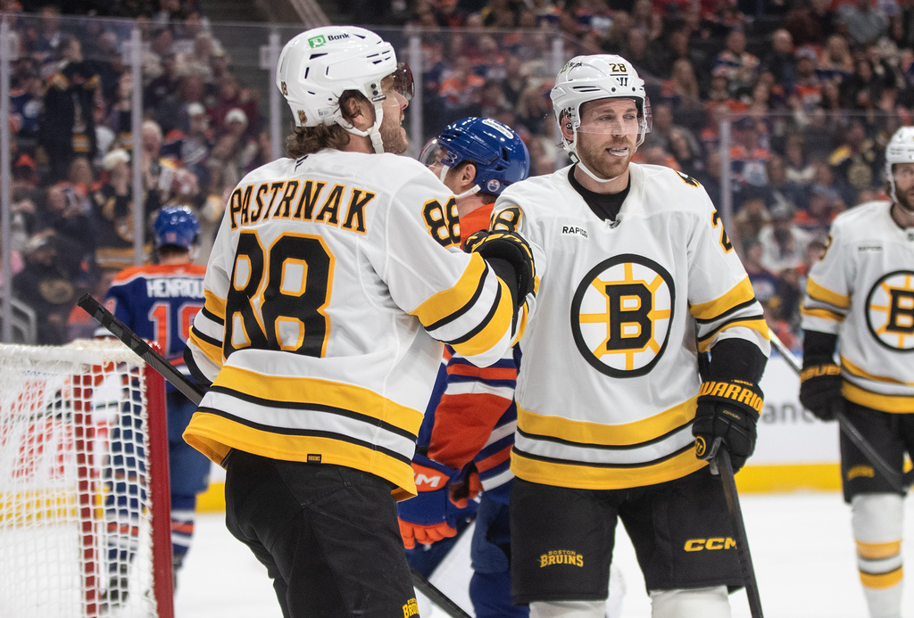 Boston Bruins' David Pastrnak (88) and Elias Lindholm (28) celebrate a goal against the Edmonton Oilers during first period NHL action in Edmonton on Wednesday, Dec. 31, 2025. (Jason Franson/The Canadian Press via AP)