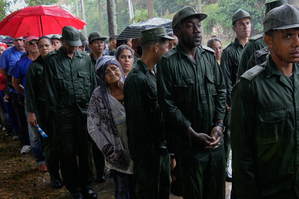 FILE - People line up in a rain shower to pay their final respects to Cuban officers who were killed in the U.S. operation that captured President Nicolas Maduro, in Havana, Cuba, Jan. 15, 2026 . (AP Photo/Ramon Espinosa, File)
