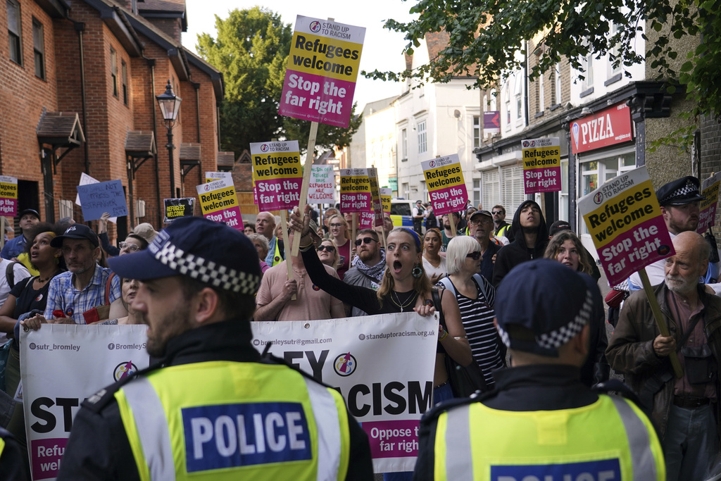 Protesters hold placards during a demonstration in Orpington near London, Friday, Aug. 22, 2025 as the dilemma of how to house asylum-seekers in Britain got more challenging for the government after a landmark court ruling this week motivated opponents to fight hotels used as accommodation.(AP Photo/Alberto Pezzali)