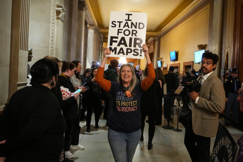 A protester celebrates as they walk outside the Indiana Senate Chamber after a bill to redistrict the state's congressional map was defeated, Thursday, Dec. 11, 2025, at the Statehouse in Indianapolis. (AP Photo/Michael Conroy)